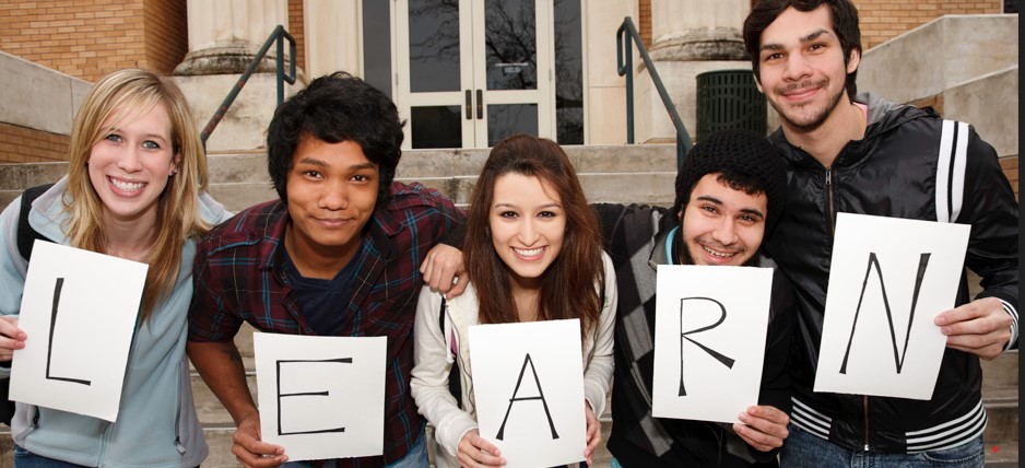 Eine Gruppe junger Leute mit dem Buchstaben Learn in der Hand.