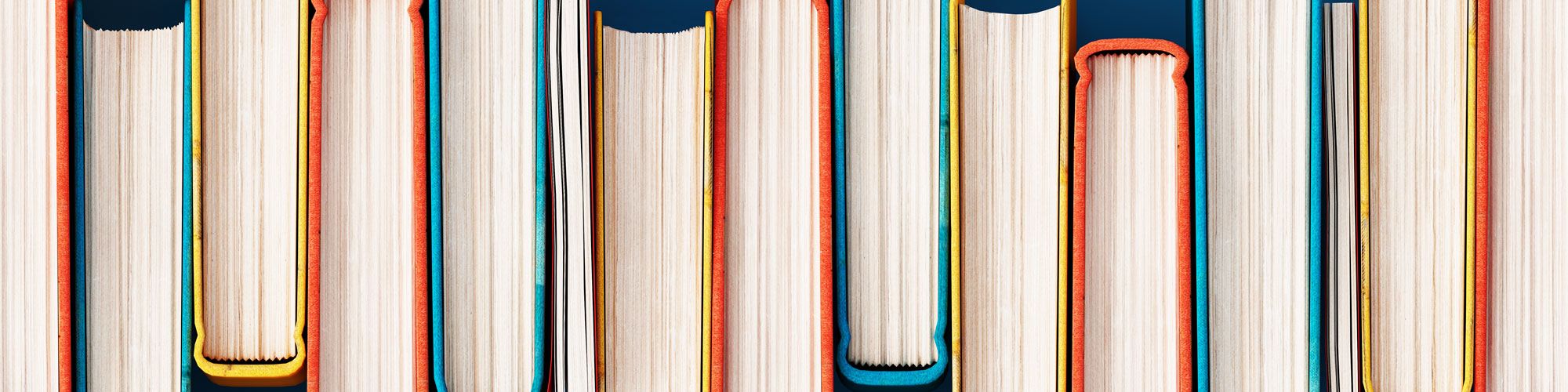 Viele Bücher, die nebeneinander stehen und von oben zu sehen sind.